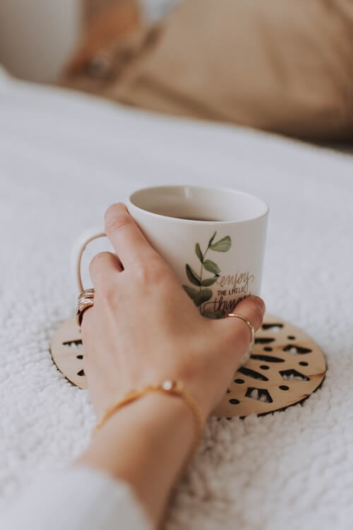 2_template-virginie-a-propos Photo d'une main tenant une tasse.